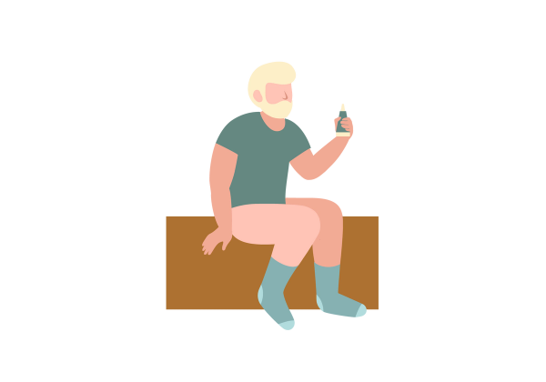 A man without pants sitting on a brown rectangle and holding a green bottle.